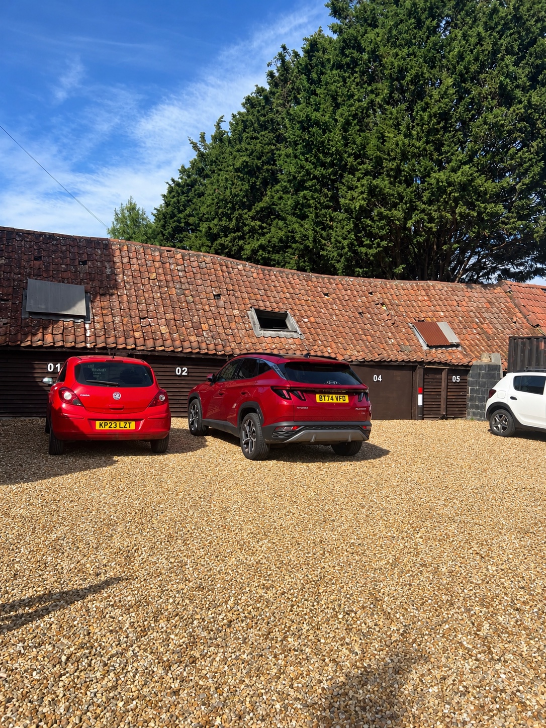 Numbered parking bays 01 to 05 beside the farm building